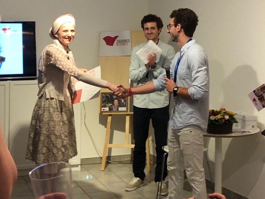 Une participante reçoit son attestation, entourée de l'équipe